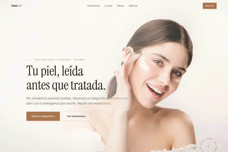 Portada de la landing de Casa Lumé: una mujer sonriendo con una pincelada de crema en el pómulo sobre fondo crema, con el titular «Tu piel, leída antes que tratada»