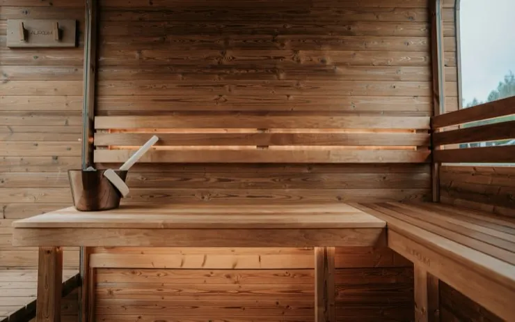 Interior del sauna de madera con balde y cucharón