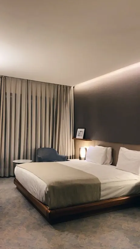 Habitación con cama matrimonial y ropa de cama blanca