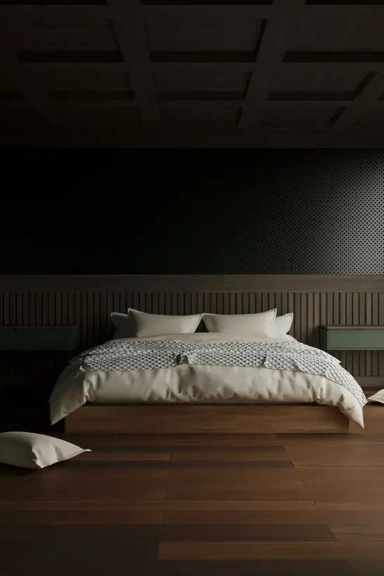 Habitación individual en penumbra con cama baja y piso de madera
