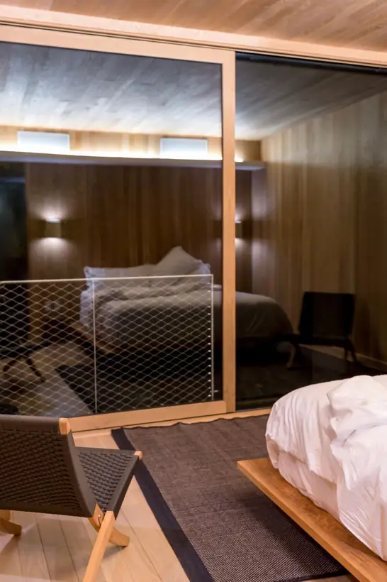 Habitación familiar de dos ambientes con el dormitorio detrás de un panel vidriado