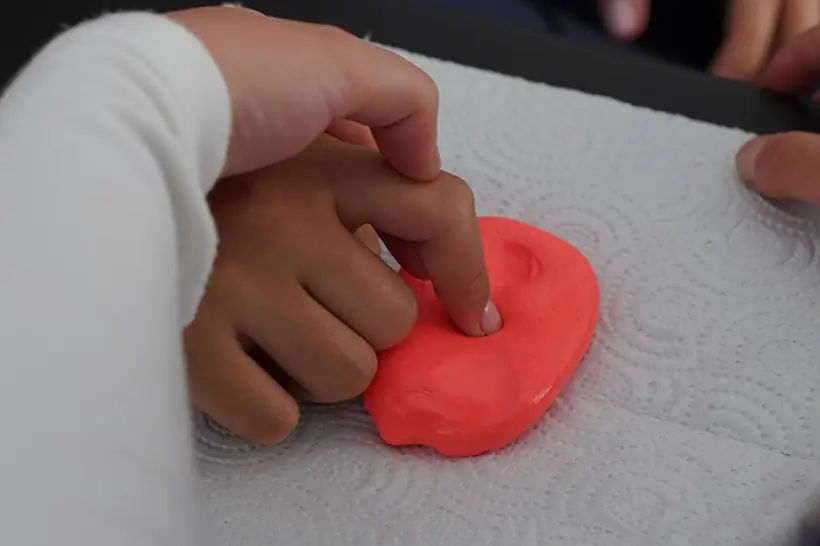 Paciente apretando masilla de rehabilitación con la mano durante un ejercicio de fuerza